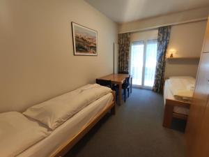 a hotel room with two beds and a table at Apartment Allod Park Haus C E03 by Interhome in Davos