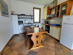 a kitchen with a wooden table and a refrigerator at Apartment La Rocca by Interhome in Castelveccana
