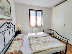 two twin beds in a bedroom with a window at Apartment La Rocca by Interhome in Castelveccana +17 photos