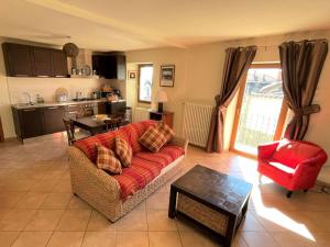 a living room with a red couch and a kitchen at Holiday Home Monte Tabor by Interhome in Carmine