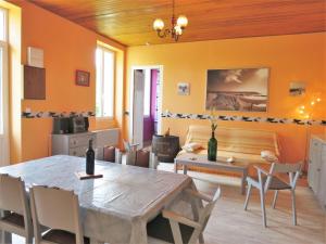 BégadanにあるHoliday Home L'Estuaire - AQB110 by Interhomeのオレンジ色の壁のダイニングルーム(テーブル、椅子付)