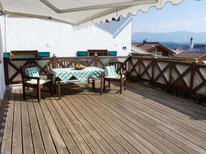 a wooden deck with a table and chairs on a balcony at Holiday Home Fischer by Interhome in Lechbruck