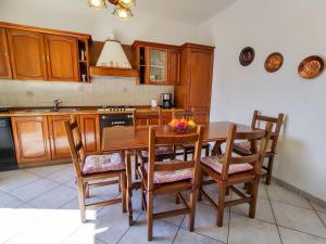 ルイーノにあるApartment Casa Riboni by Interhomeのキッチン(木製キャビネット、木製テーブル、椅子付)