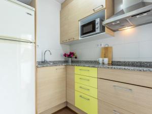 cocina con armarios de madera y microondas en Apartment Terecel Salou-1 by Interhome, en Salou