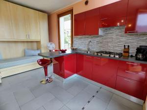 Consiglio di RumoにあるApartment Bellavista - Monolocale 1-piano - GRV390 by Interhomeの赤いキャビネットと赤いスツール付きのキッチン