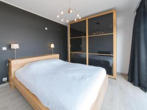 1 dormitorio con cama blanca y ventana grande en Apartment Residentie Astrid-6 by Interhome, en Bredene