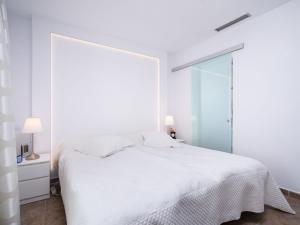 a white bedroom with a bed and a large window at Holiday Home Vista al Mar by Interhome in Benitachell