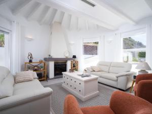 a living room with white furniture and a fireplace at Holiday Home Vista al Mar by Interhome in Benitachell