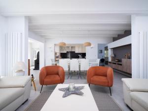 a living room with a white couch and orange chairs at Holiday Home Vista al Mar by Interhome in Benitachell