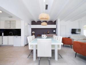 a kitchen and dining room with a white table and chairs at Holiday Home Vista al Mar by Interhome in Benitachell