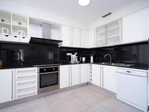 a white kitchen with white cabinets and appliances at Holiday Home Vista al Mar by Interhome in Benitachell +37 photos
