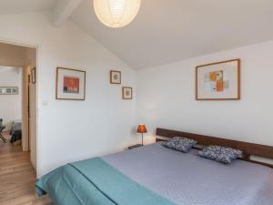 ミミザン・プラージュにあるHoliday Home Le Hameau des Pêcheurs 1 by Interhomeの白い部屋に青いベッドが備わるベッドルーム1室