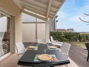 a dining table and chairs on a patio at Holiday Home Le Hameau des Pêcheurs 1 by Interhome in Mimizan-Plage