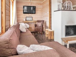 a living room with a couch and a fireplace at Holiday Home Saaruan aurinko by Interhome in Ruka
