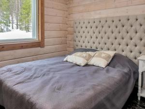 a bed with two pillows in a room with a window at Holiday Home Saaruan aurinko by Interhome in Ruka