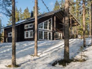 a log cabin in the snow with trees at Holiday Home Levijoutsen by Interhome in Levi