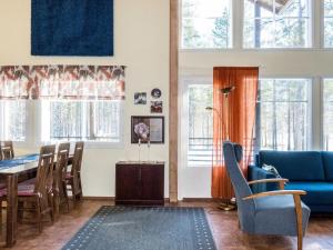 a living room with a table and a blue couch at Holiday Home Levijoutsen by Interhome in Levi