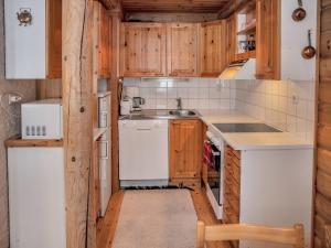 - une petite cuisine avec des appareils blancs et des armoires en bois dans l'établissement Holiday Home Yllästys 6 by Interhome, à Ylläsjärvi