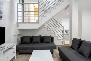 a living room with a couch and a staircase at Casa vacacional en Caños de Meca in Los Caños de Meca