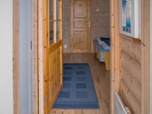 a wooden cabin with a door and a rug in a room at Holiday Home Vaeltajankulma huoneisto 3 by Interhome in Ylläs