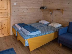 a small bed in a wooden room with a chair at Holiday Home Vaeltajankulma huoneisto 3 by Interhome in Ylläs