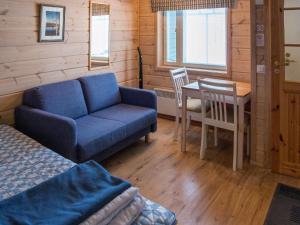 a room with a couch and a table and a chair at Holiday Home Vaeltajankulma huoneisto 3 by Interhome in Ylläs