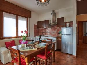 a kitchen with a table with chairs and a refrigerator at Apartment Margi by Interhome in Dongo