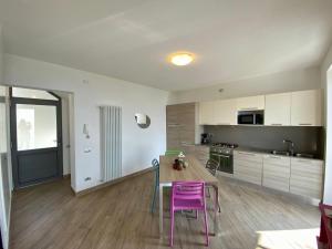 cocina con mesa y sillas moradas en una habitación en Apartment Margherita-4 by Interhome en Gravedona