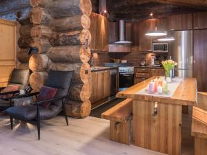 a kitchen with a log wall and a table and chairs at Holiday Home Harjula by Interhome in Nissi