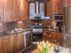 a kitchen with wooden cabinets and stainless steel appliances at Holiday Home Harjula by Interhome in Nissi +23 photos