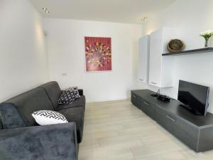 ein Wohnzimmer mit einem Sofa und einem TV in der Unterkunft Apartment Titti - GLA133 by Interhome in Gera Lario