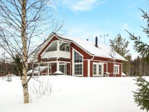 a red house in the snow with a tree at Holiday Home Pyrykieppi by Interhome in Sonka