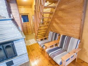a room with two chairs and a staircase in a log cabin at Holiday Home Ylläsrova b5 - kasku by Interhome in Ylläsjärvi +14 photos