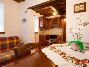 a kitchen with a table with a vase of flowers on it at Holiday Home Paradiso I by Interhome in Bolognana
