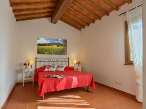 San Donato in PoggioにあるHoliday Home Casa San Martino by Interhomeの赤いベッドと壁に絵画が飾られたベッドルーム1室