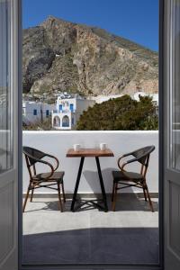 a table and two chairs in front of a window at Mountain and Sea Suites in Kamari