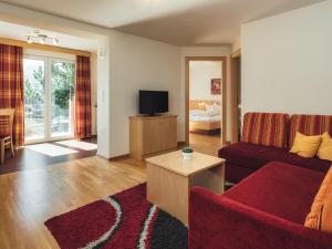 ラディスにあるApartment Ladis-5 by Interhomeの赤いソファとテレビのあるリビングルーム