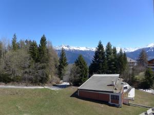 a house in a field with mountains in the background at Apartment Barzettes-Vacances 553 - Entrée N- 14 by Interhome in Vermala