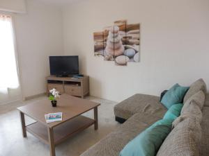 a living room with a couch and a coffee table at Apartment Les Mimosas-1 by Interhome in Saint-Aygulf