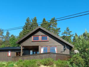 una casa con ventanas rojas en el lateral. en Chalet Koven - SOW114 by Interhome, en Øyuvstad