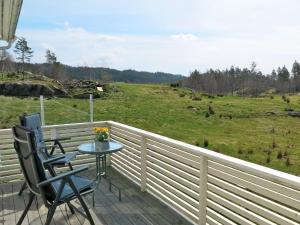 uma varanda com uma mesa e cadeiras e um campo em Holiday Home Der ute - SOW441 by Interhome em Brådland