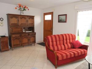 ein Wohnzimmer mit einem roten Sofa und einem Schrank in der Unterkunft Holiday Home l'Hermine by Interhome in Ploubazlanec