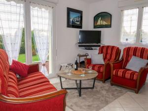 a living room with red chairs and a tv at Holiday Home l'Hermine by Interhome in Ploubazlanec