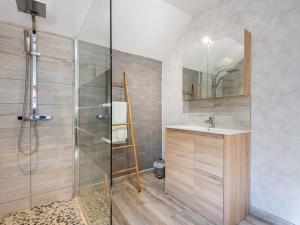 a bathroom with a shower and a sink and a mirror at Chalet Le Petit Chalet by Interhome in La Haye-dʼEctot +12 photos