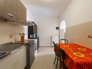 Apartment Margherita by Interhome في مورتولا إنفريوري: مطبخ مع طاولة مع قماش الطاولة الحمراء