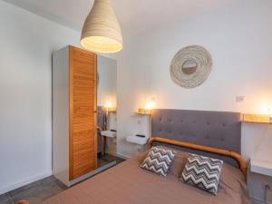 a bedroom with a bed with a wooden headboard at Holiday Home Scorpina by Interhome in Sari Solenzara +13 photos