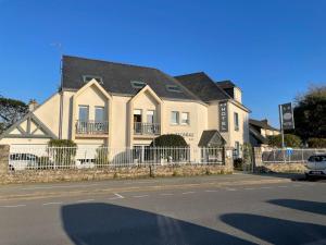 ein großes Haus mit einem Zaun davor in der Unterkunft Hotel La Licorne in Carnac