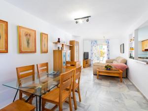 een eetkamer en een woonkamer met een glazen tafel en stoelen bij Apartment Cala Verde II - AMU615 by Interhome in Salobreña