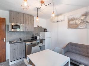 a kitchen and living room with a table and a couch at Holiday Home Sepia by Interhome in Sari Solenzara
