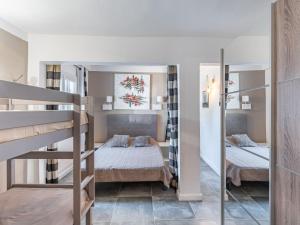 a bedroom with two bunk beds and a mirror at Holiday Home Sepia by Interhome in Sari Solenzara